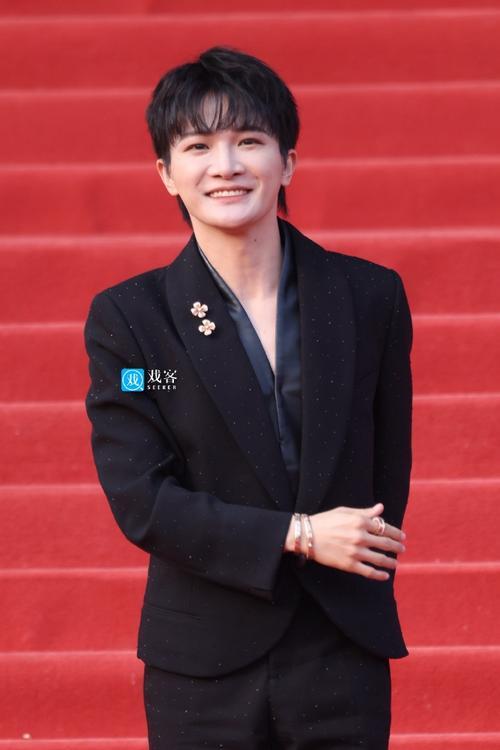 第十六届北京国际电影节闭幕红毯上，周深惊艳亮相。他身着精致黑钻西装，造型优雅精致