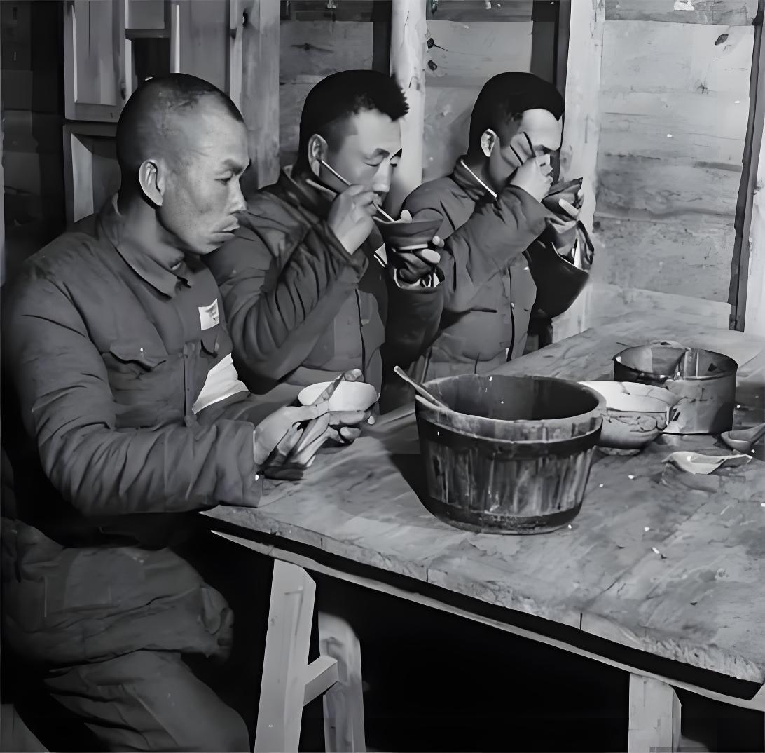 1950 年代初，抚顺战犯管理所内的日本战俘，正在木质板房的食堂等待吃饭。三个人