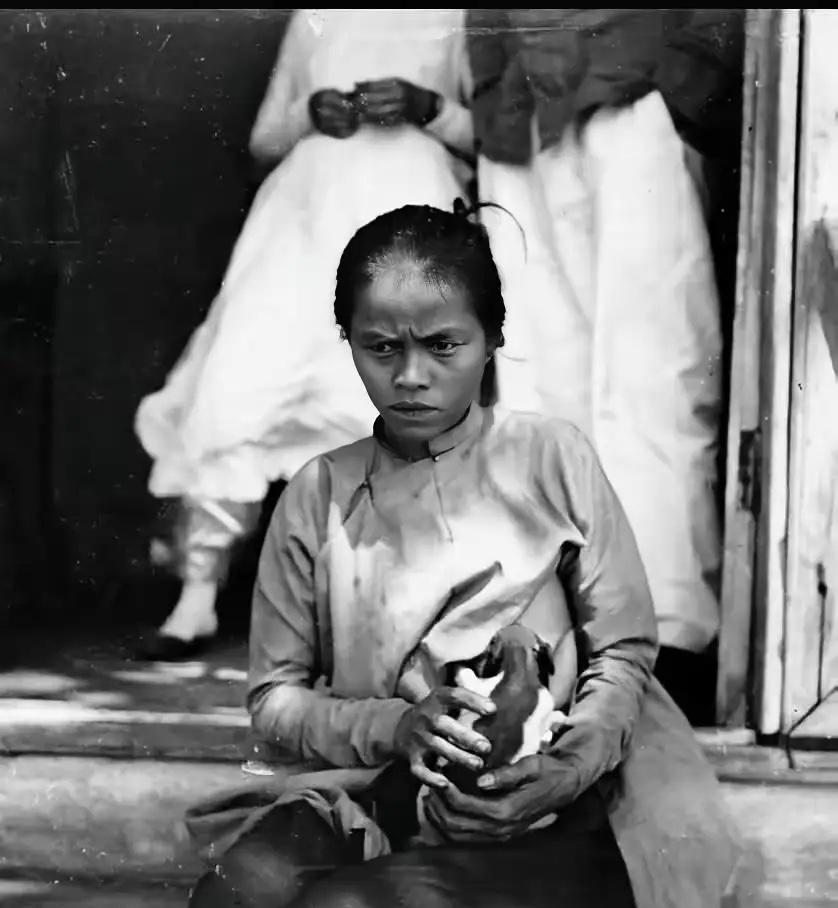 图中，这是一位越南妇女正在给法国官员的狗喂奶，照片拍摄于法国殖民越南期间！

​