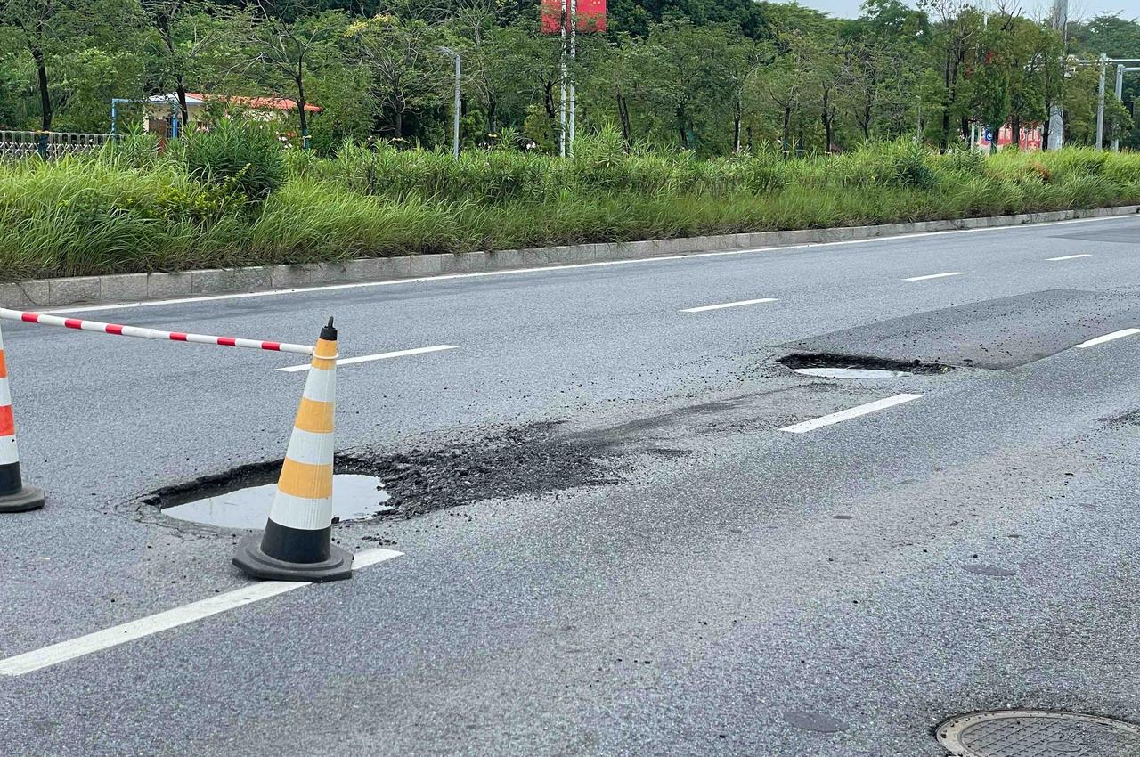 【玉林某道路的机动车道上有两个路坑】

6月27日，网友爆料称：玉林市某道路红绿