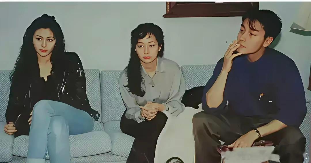 很多年以前，年轻的张国荣优雅的抽着烟，左侧是大美女关之琳，中间的小美女长的也不错