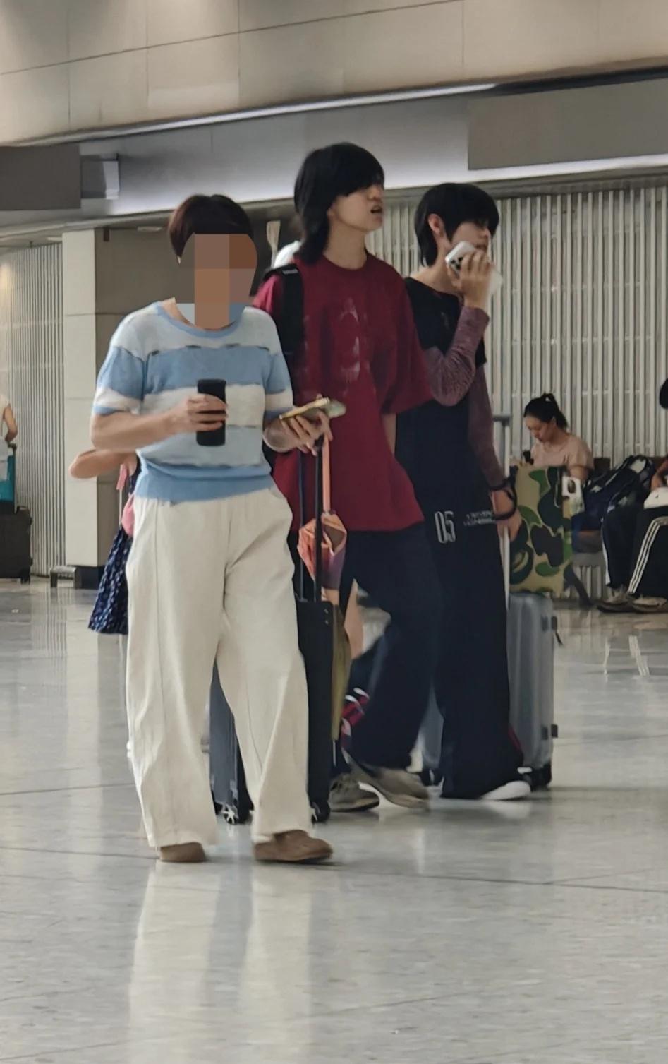 右边黑色衣服这个是练习生吗
今天下午在香港西九龙高铁站候车室遇到的，在人群中别出