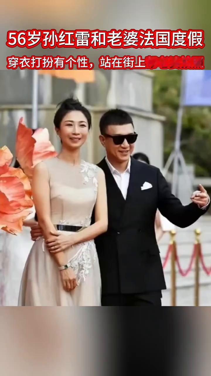 56岁孙红雷和老婆法国度假，穿衣打扮有个性，站在街上帮老婆拍照。