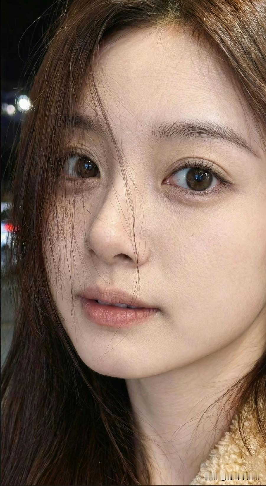 夜晚的灯光下，少女温柔的眼神令人心动。