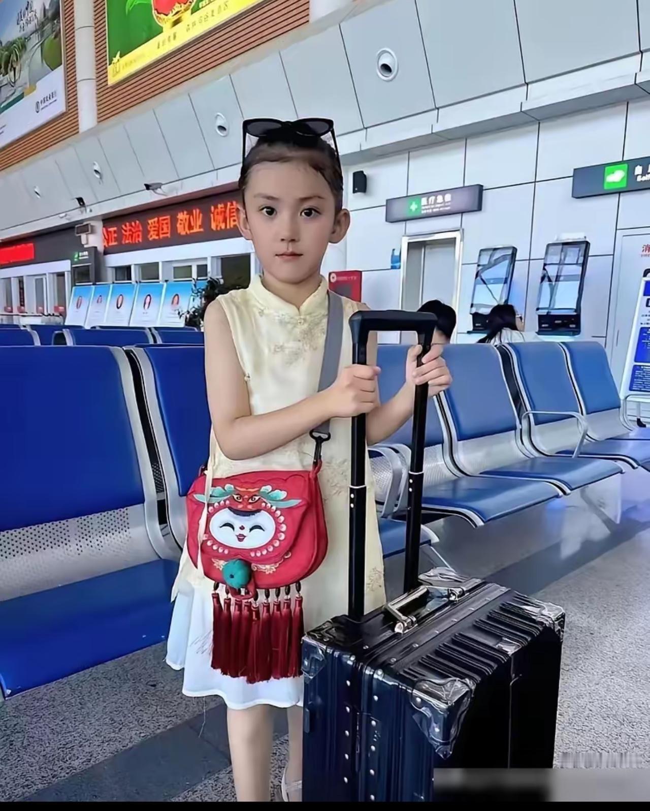 徐州机场，一个不到6岁的小女孩拖着行李箱，斜挎着红色小背包，她由爸爸送到机场，准