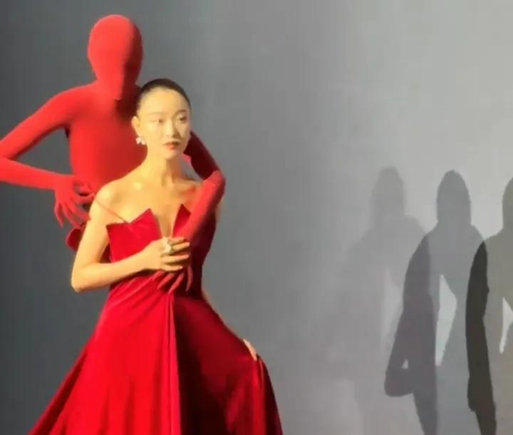 白忙活了！
倪妮在活动上走红毯，一身红色抹胸裙惊艳亮相，而身上却背了一个小红人，