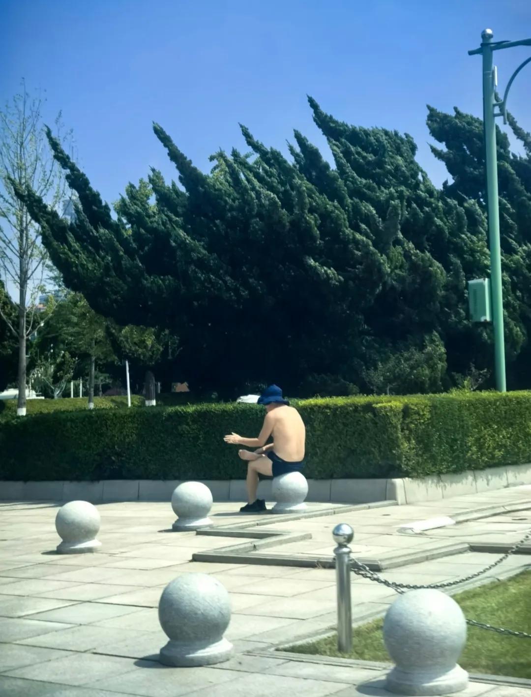 这大热天的，大叔竟然坐在石球上晒太阳，这操作谁懂啊？