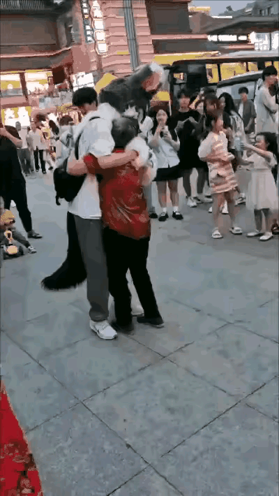 大妈精神好激动，
抱着小伙用力拱。
周围看客直瞪眼，
个个摇头看不懂！