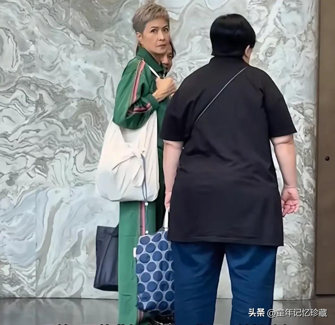 短发女神邵美琪在珠海，一身墨绿色套装，恨天高黑色鞋子，十分休闲，肩挎白色收纳包包