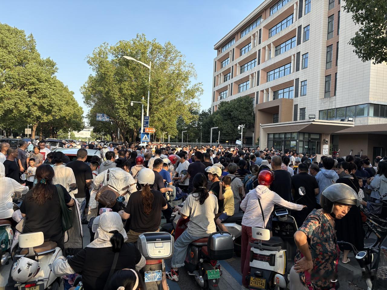 建议错峰放学，可以错大点时间，学校门口不能光有交没有通。

家长们就站在马路中间