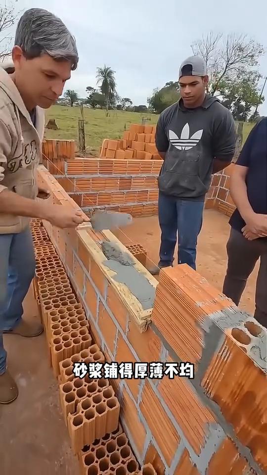 老师傅的砌砖绝活。
注意看，老师傅准备展示自己的砌砖绝活。旁边的徒弟老老实实站着