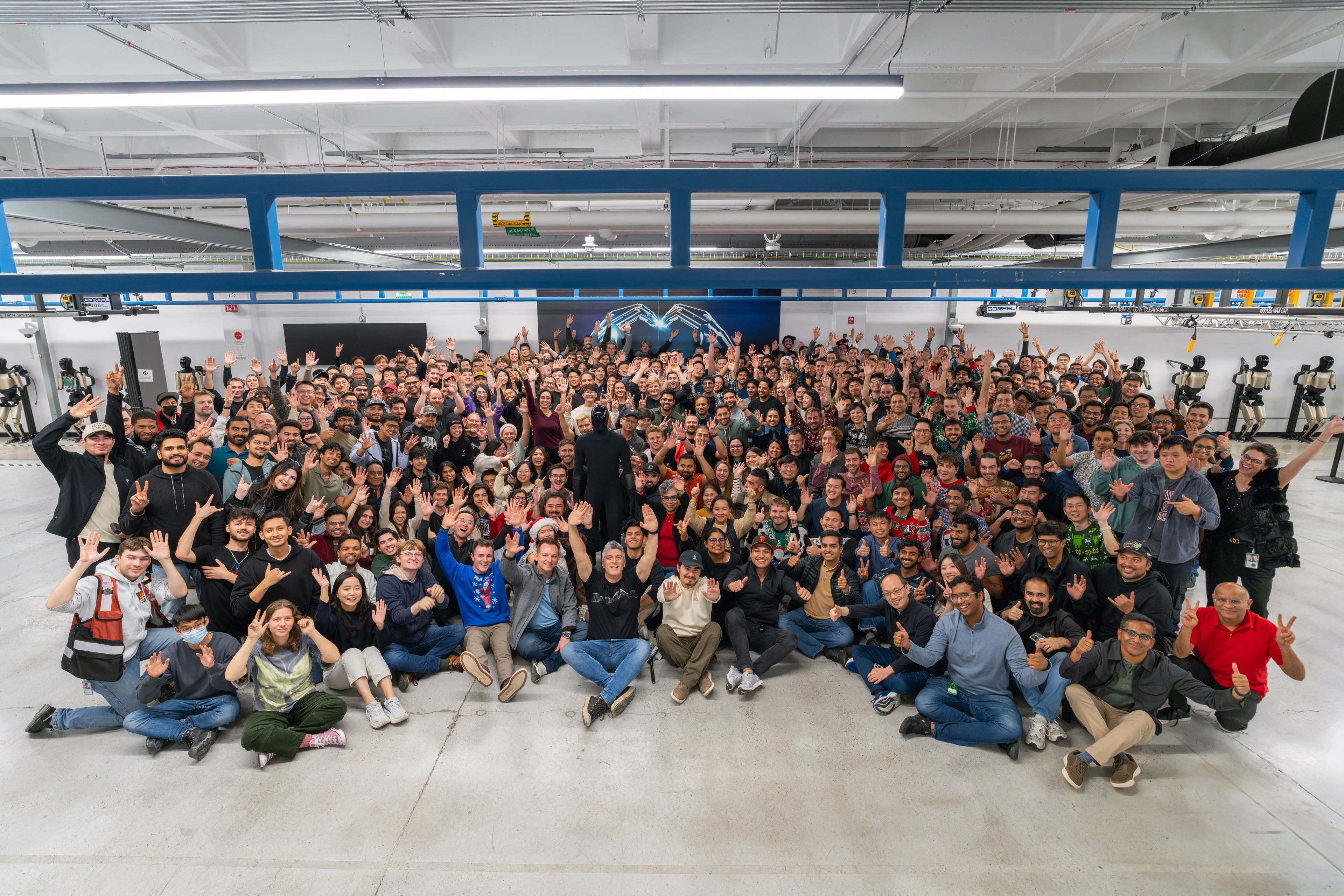 Optimus 团队合影，中间那个机器人疑似 v3。 