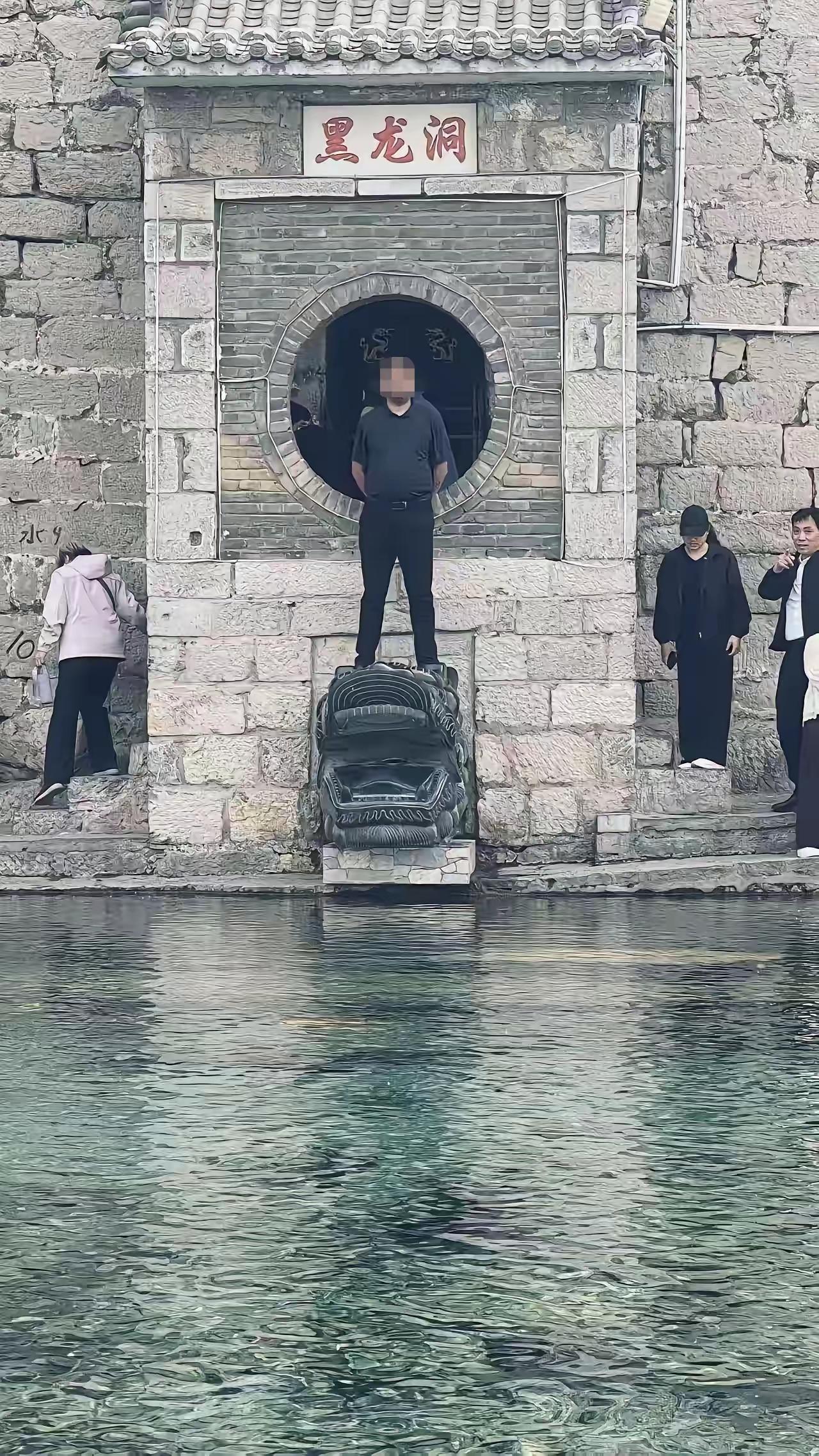 一个男子咋想的，他敢踩在龙头上照像，旁边的人看到后，觉得这个男人太胆大了，像这样