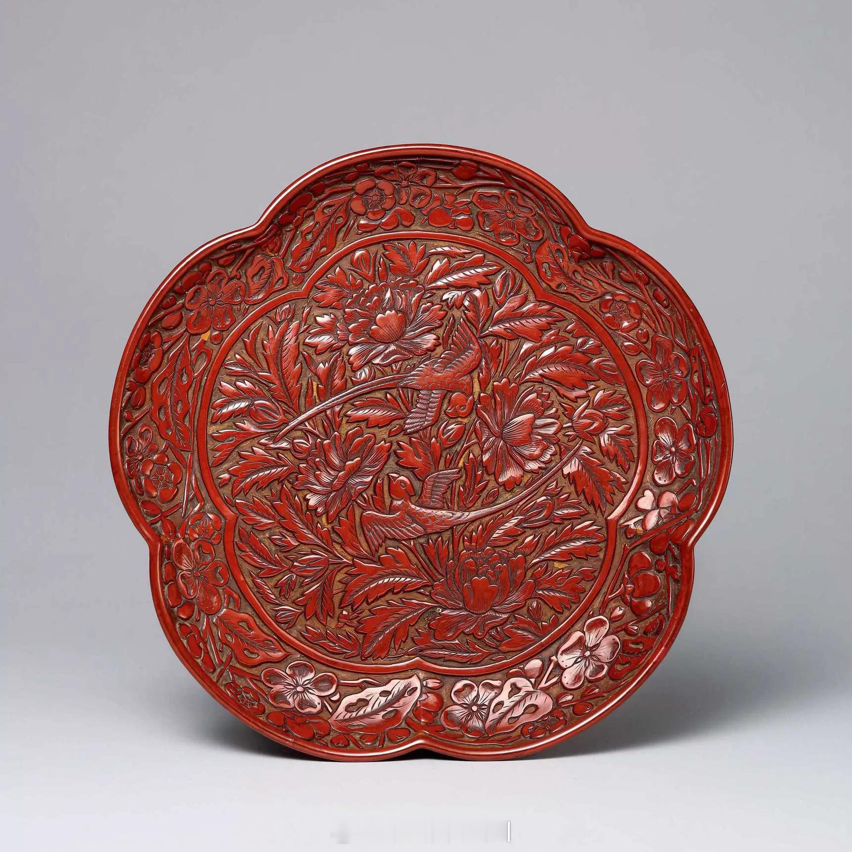 髹饰录 | 明早期 剔红双鹦鹉牡丹图梅花口盘盘作五瓣梅花形，正面饰双鹦鹉牡丹图，