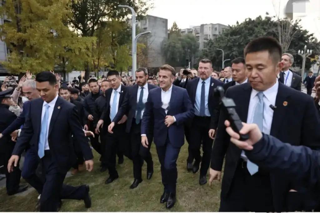 12月5日马克龙夫妇访华期间品尝北京烤鸭，巩俐低调陪同，她身着黑衣扎丸子头，气场