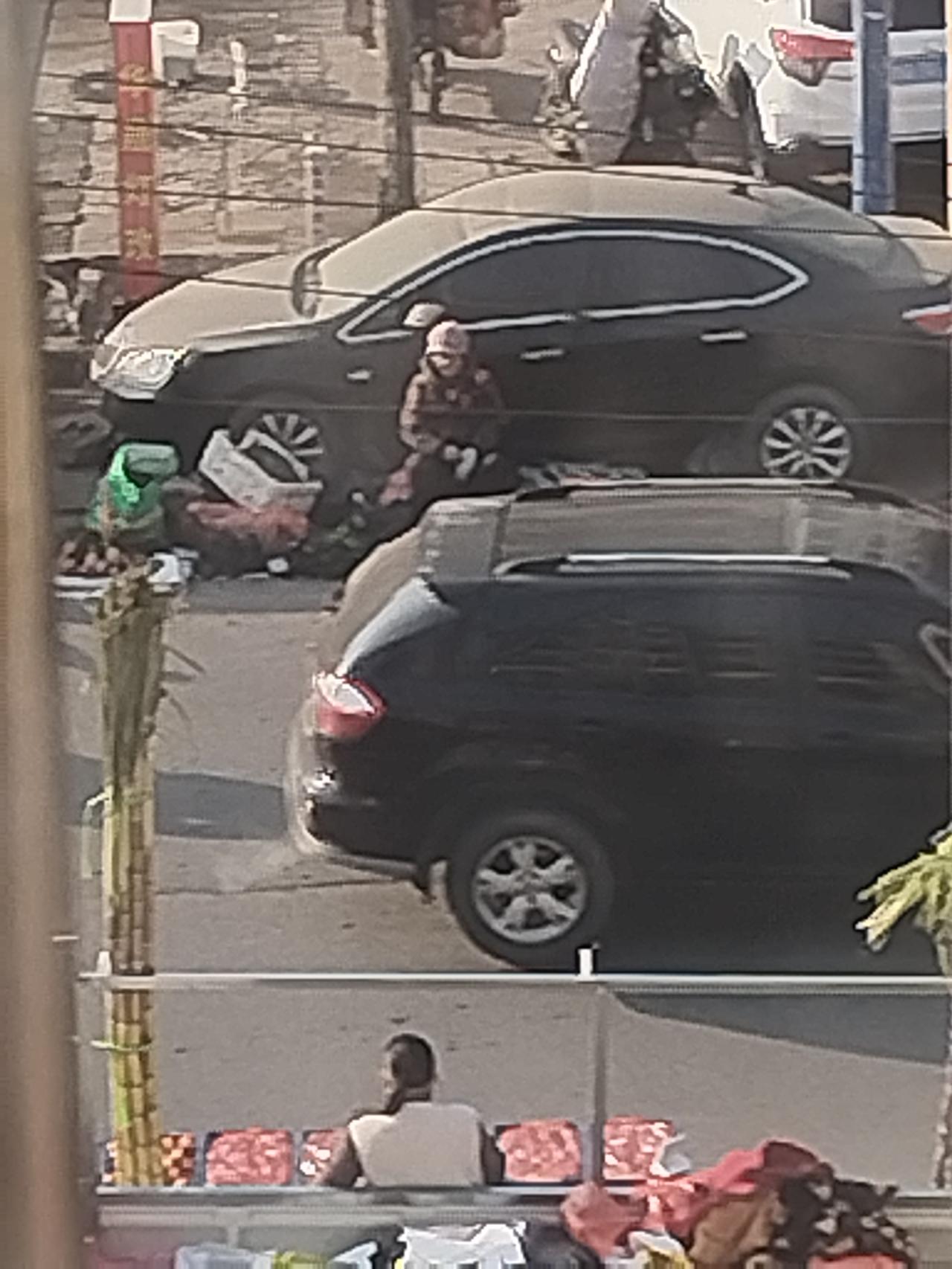 停车位前都摆地摊了，车主很无奈的与摊主交涉。