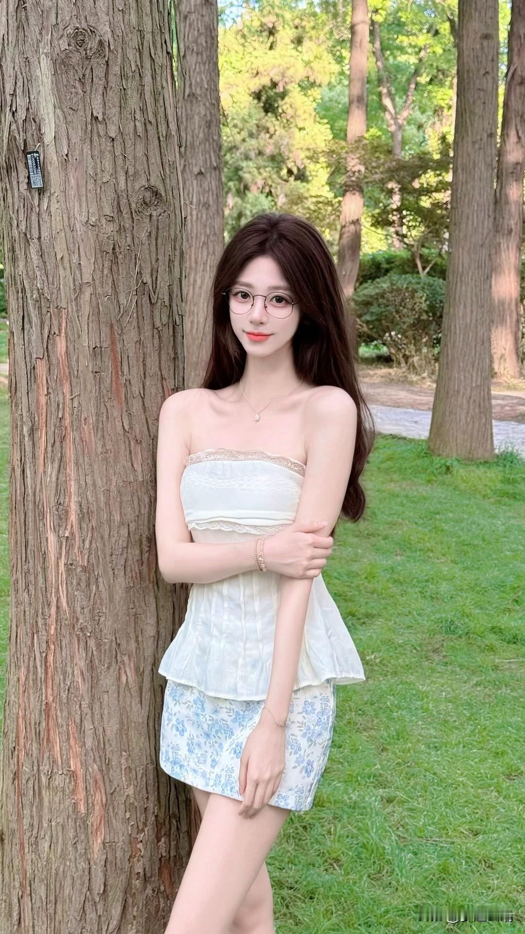 在绿意盎然的公园里，少女倚树而立，清新自然。