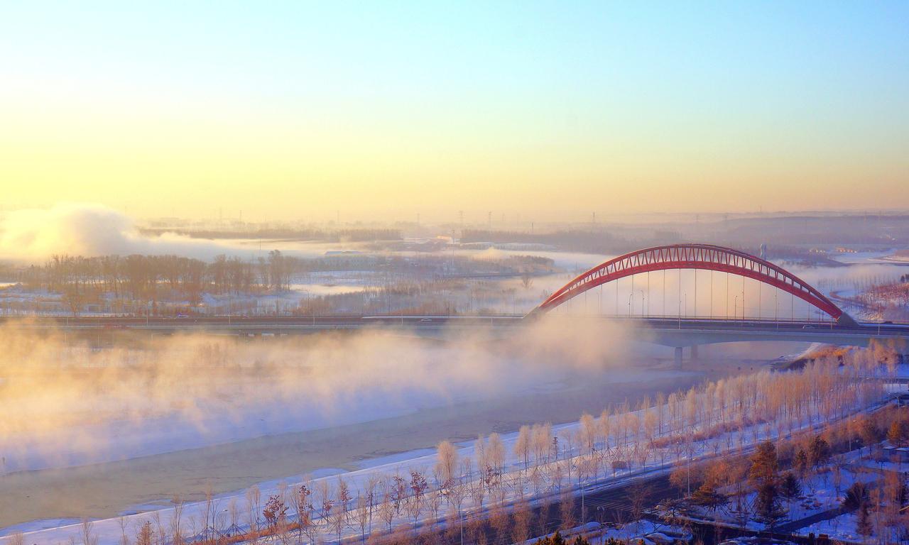 《伊通河晓雾》
 
朝日衔着东方的赤霞探出头来。远远望去，伊通河正蒸腾着白雾——