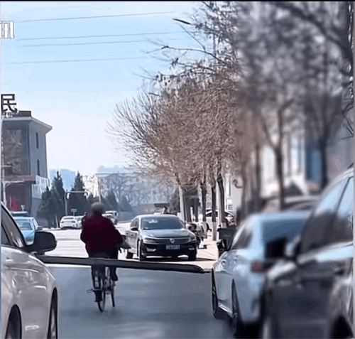 老人用自行车拖着一块彩钢板，去卖废品。一路上，剐蹭了好几辆车。
目击者介绍，其实