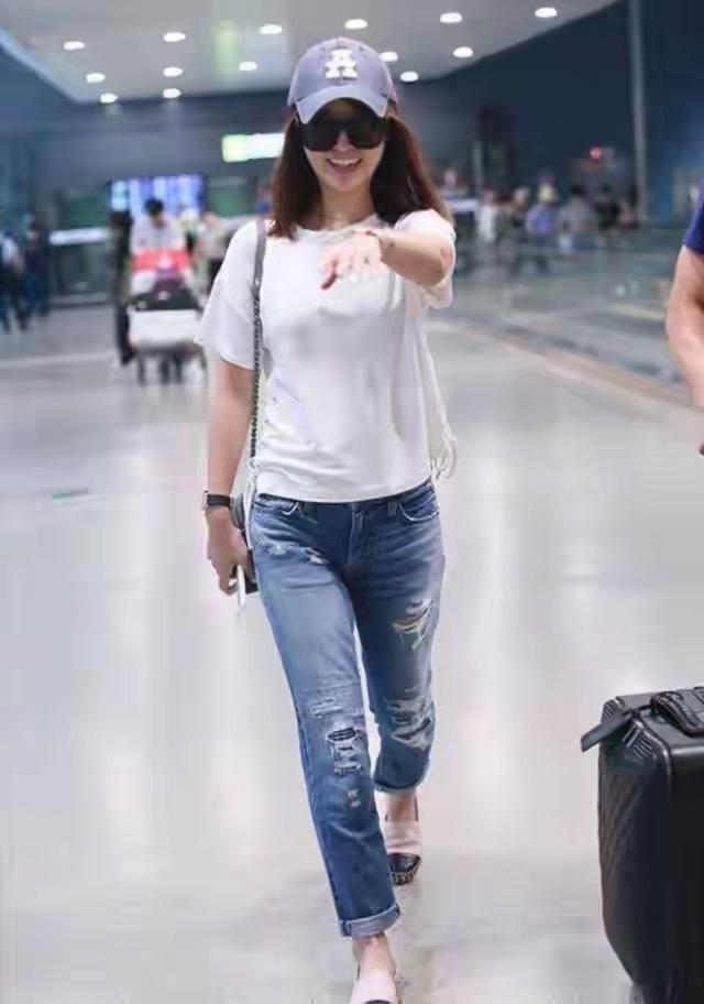 林心如上半身穿的白T恤是基础款，版型宽松，下摆侧边还有点抽绳设计，不是死板的直筒
