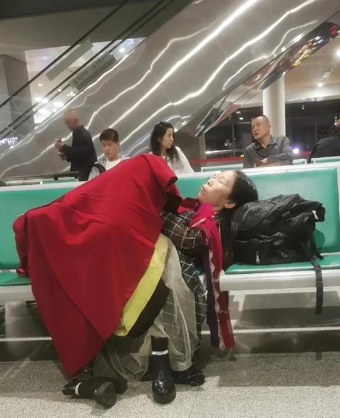 火车站候车室里，这大姐躺得也太自在了吧，感觉像是在自家床上一样。这种场景让人想起