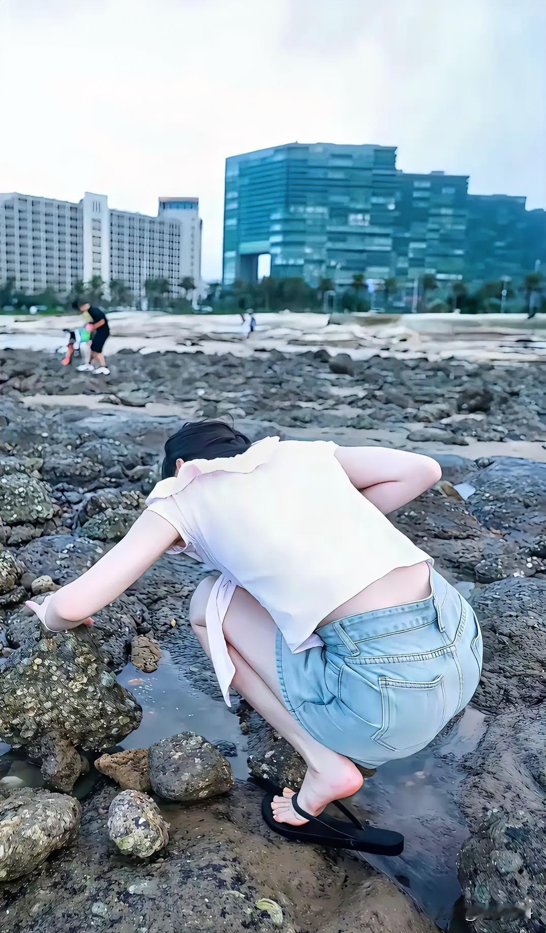 中午饭后陪女同事在公司附近散步，走到河边沙滩时她突发奇想硬要到沙滩上走走，还蹲下