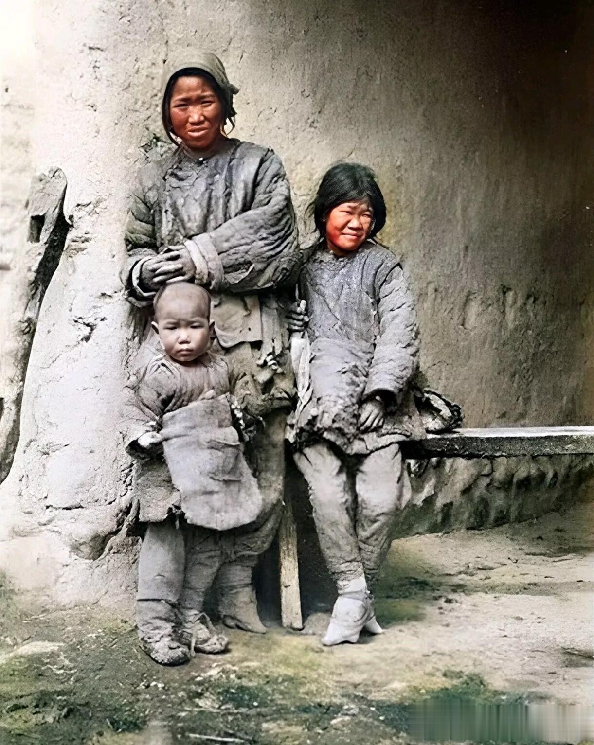 晚清时期，外国人镜头下清朝普通的一家三口，照片中，一个母亲带着两个孩子，穿着破破