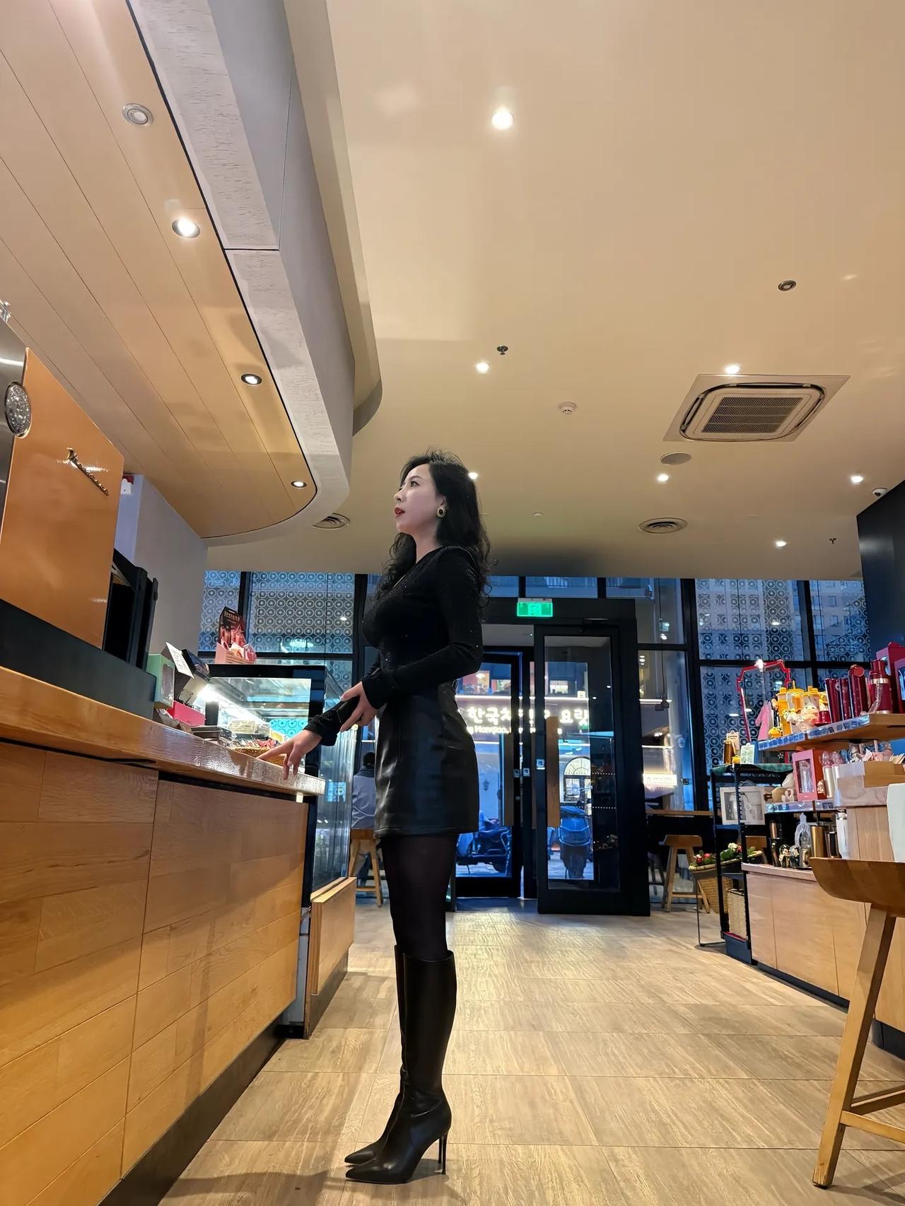 都市夜景中的时尚咖啡馆，优雅女士倚窗而坐，享受宁静时光。