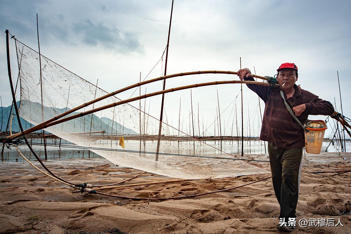 滩涂渔者
       阴天的滩涂，沙泥印着岁月的痕。一位渔人戴着红帽，肩扛竹制