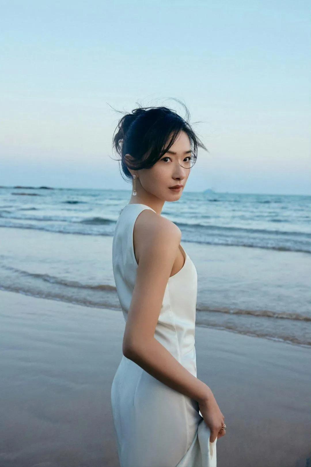 万茜身材白色礼裙与海浪共舞，气质温柔明媚，优雅迷人。