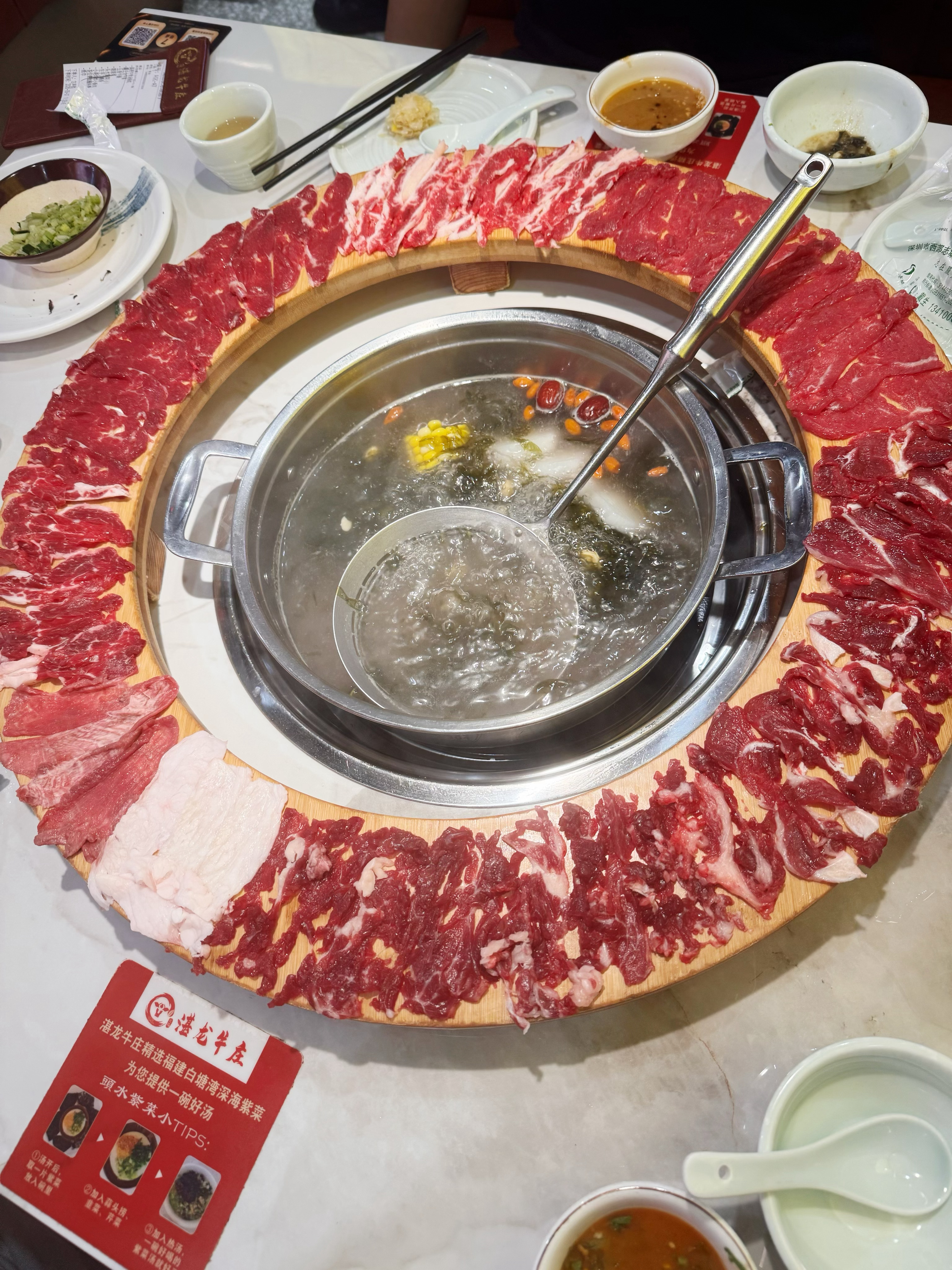 咕噜咕噜的牛骨清汤沸腾翻滚，新鲜现切牛肉一圈铺开，肥瘦纹理分明。欢乐颂这家牛肉火