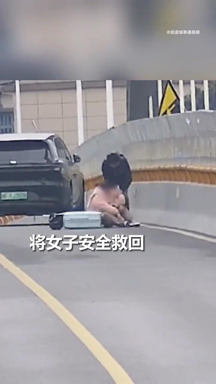 太惊险了，女子一只脚已悬在桥外，黑衣大哥冲过去一把拽回。这反应速度，这毫不犹豫的