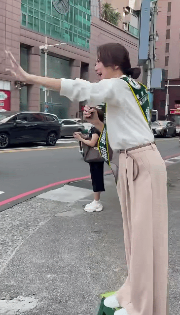 民进党这个戴玮姗真逗，大清早的站在凳子上对着行驶的车辆说“早安！谢谢小姐！”脸皮