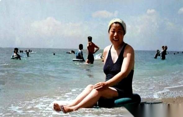 这是一张1958年的老照片，北戴河。
照片里的邓颖超，笑得像个孩子。
但你不知道