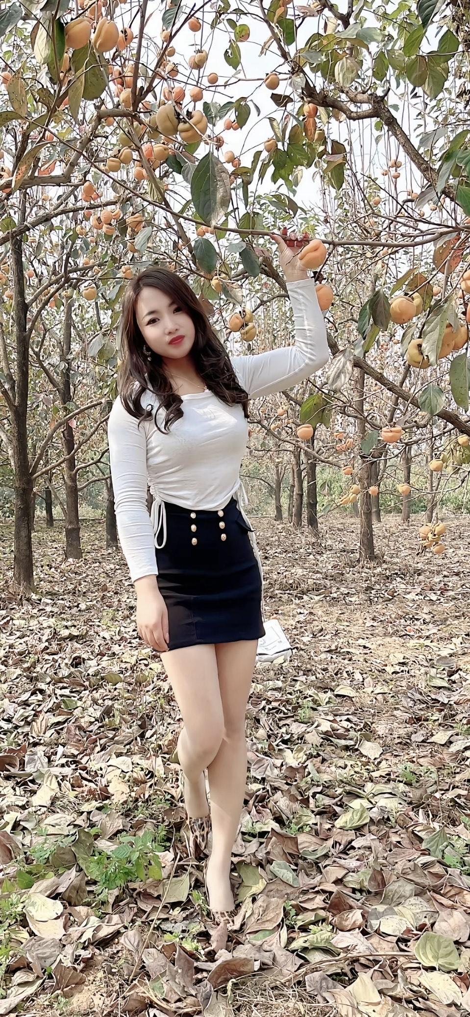 秋日果园里的甜美少女，与丰收的果实亲密合影。