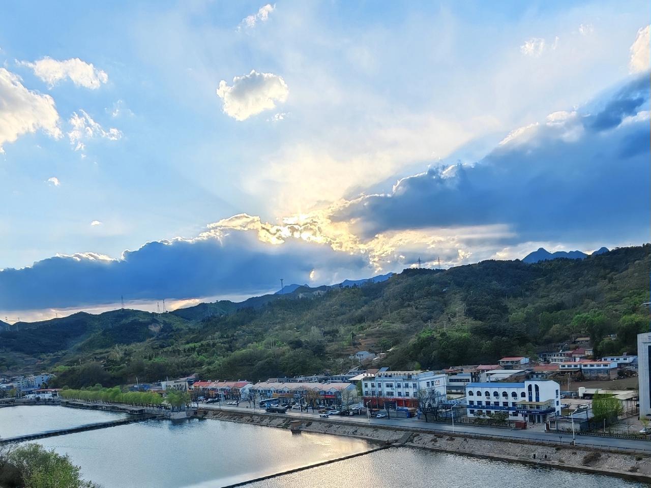 夕阳西下，那太阳被云雾缭绕着，像被蒙上了一层薄纱，散发着朦胧又迷人的光。河水在余