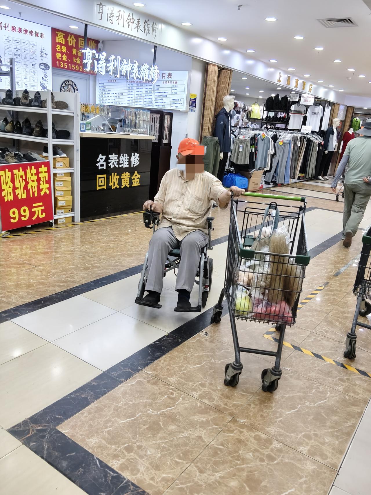 从幸福超市结账出来，看到一个大爷坐着电动轮椅，一只手操控轮椅，另一只手推着购物车