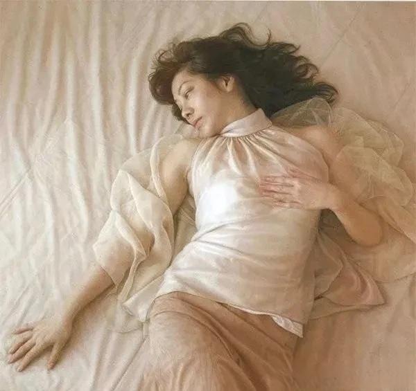 一位女士躺在柔软的床上，神情安详。