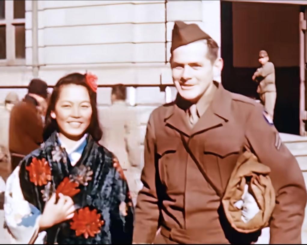 ，日本，一名美国大兵与一名打扮的花枝招展的日本女人合影，他俩开心的看着镜头！