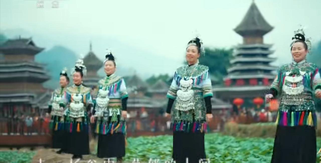 侗寨的鼓楼前，身着银饰盛装的苗族姑娘们列队而立，衣袂间的银饰叮当作响，尽显民族风