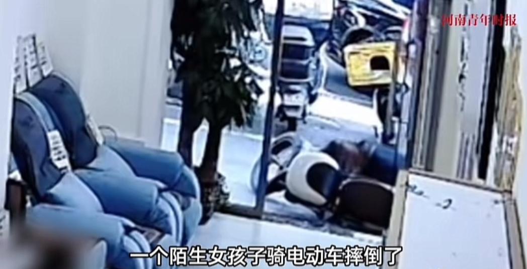 女子骑车在一美甲店门口摔倒，还把隔壁商户的电动车撞裂口了，而后没吭一声便走了。怎