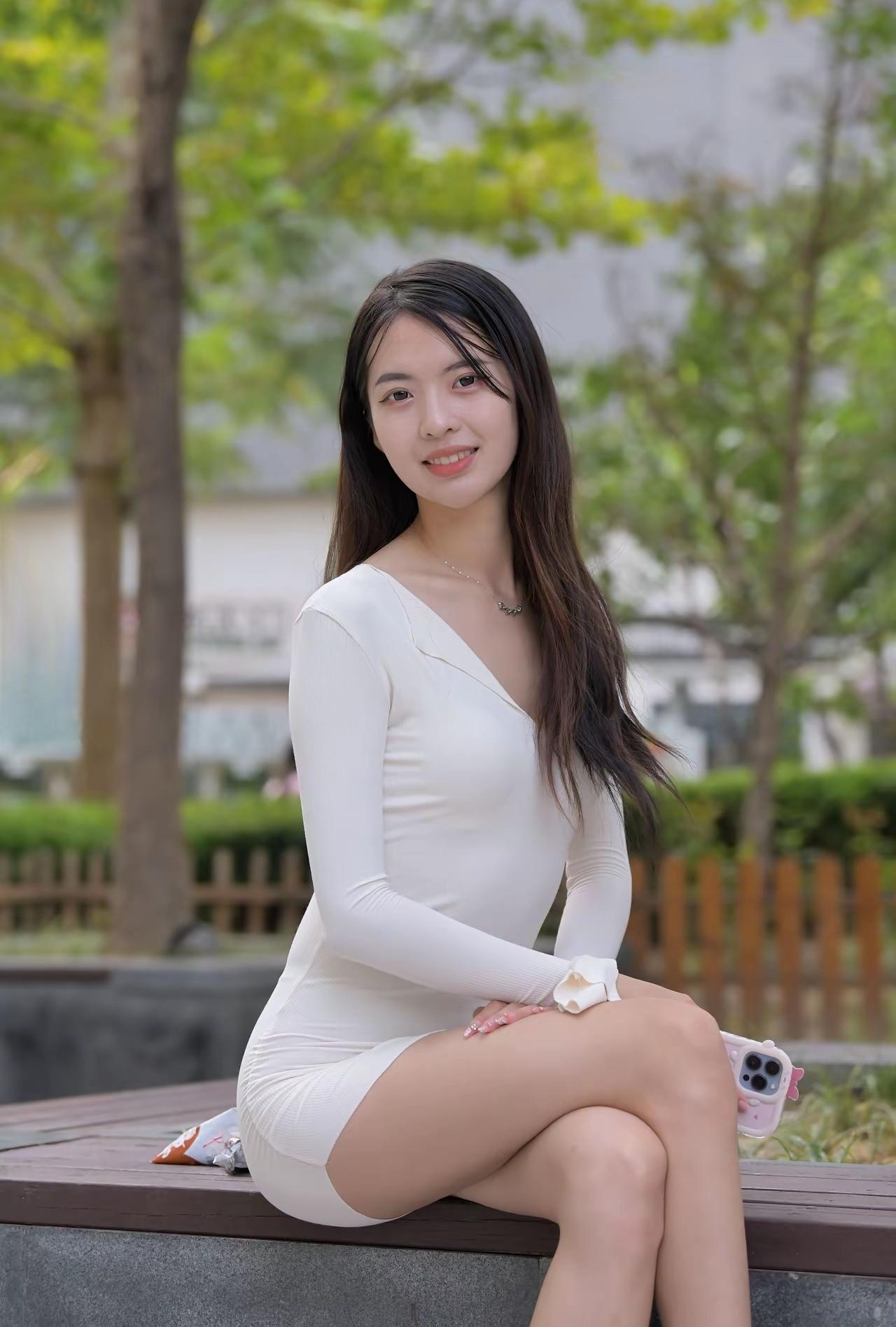 这位小姐姐坐在公园长椅上。