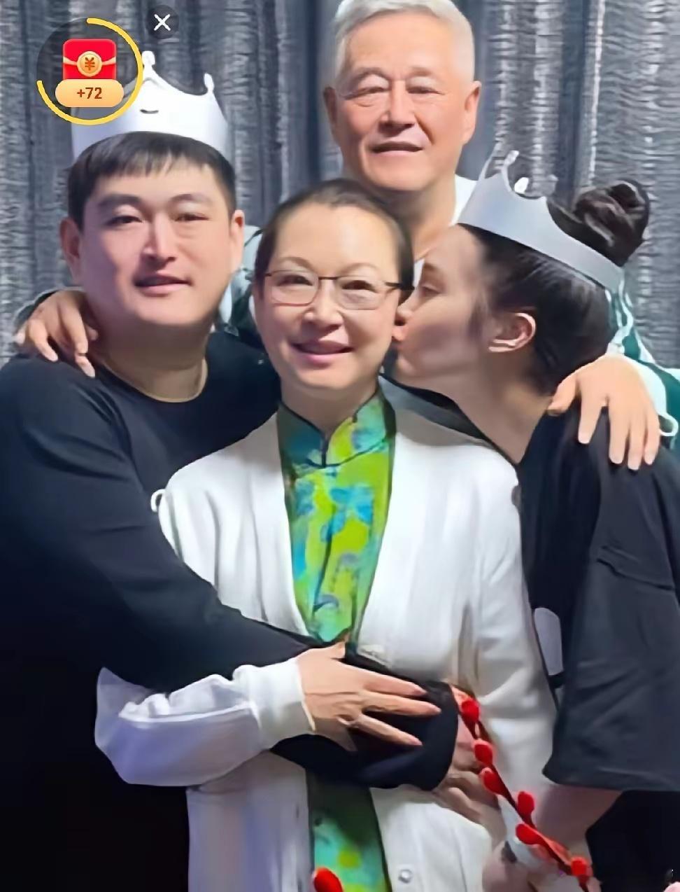 照片中马丽娟是最幸福的，儿子赵一楠从左侧环抱母亲，女儿赵珈萱从右侧亲吻母亲脸颊，