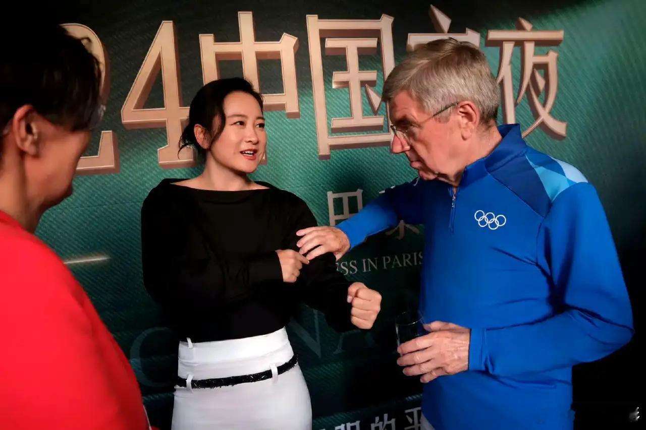 贾玲和奥委会主席巴赫互秀肌肉，巴赫捏了捏贾玲胳膊上的肌肉，又展示了一下自己手臂的