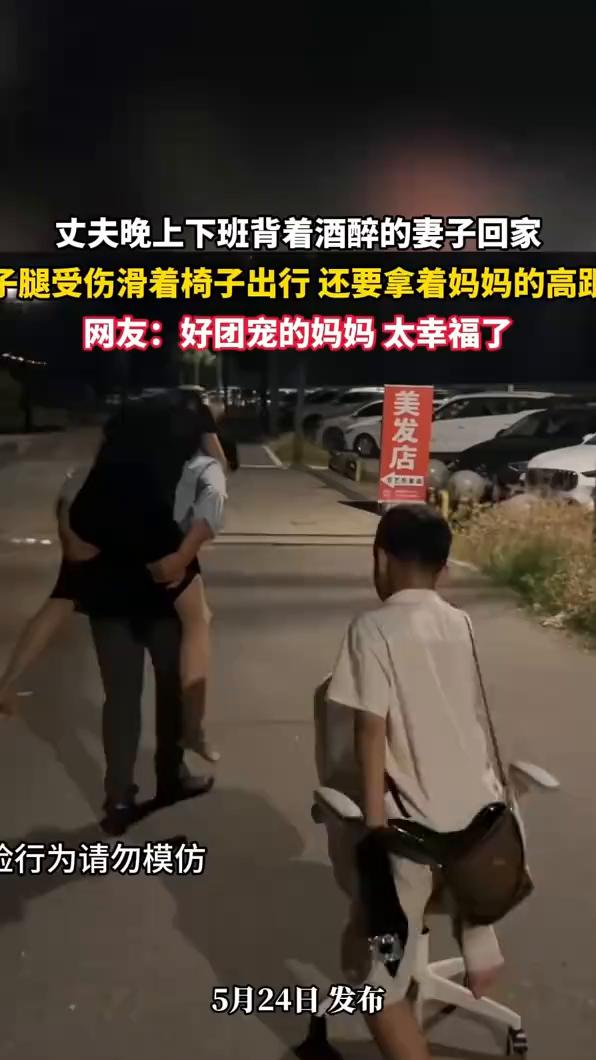 丈夫晚上下班背着酒醉的妻子回家，妻子腿受伤滑着椅子出行，还要拿着妈妈的高路。网友