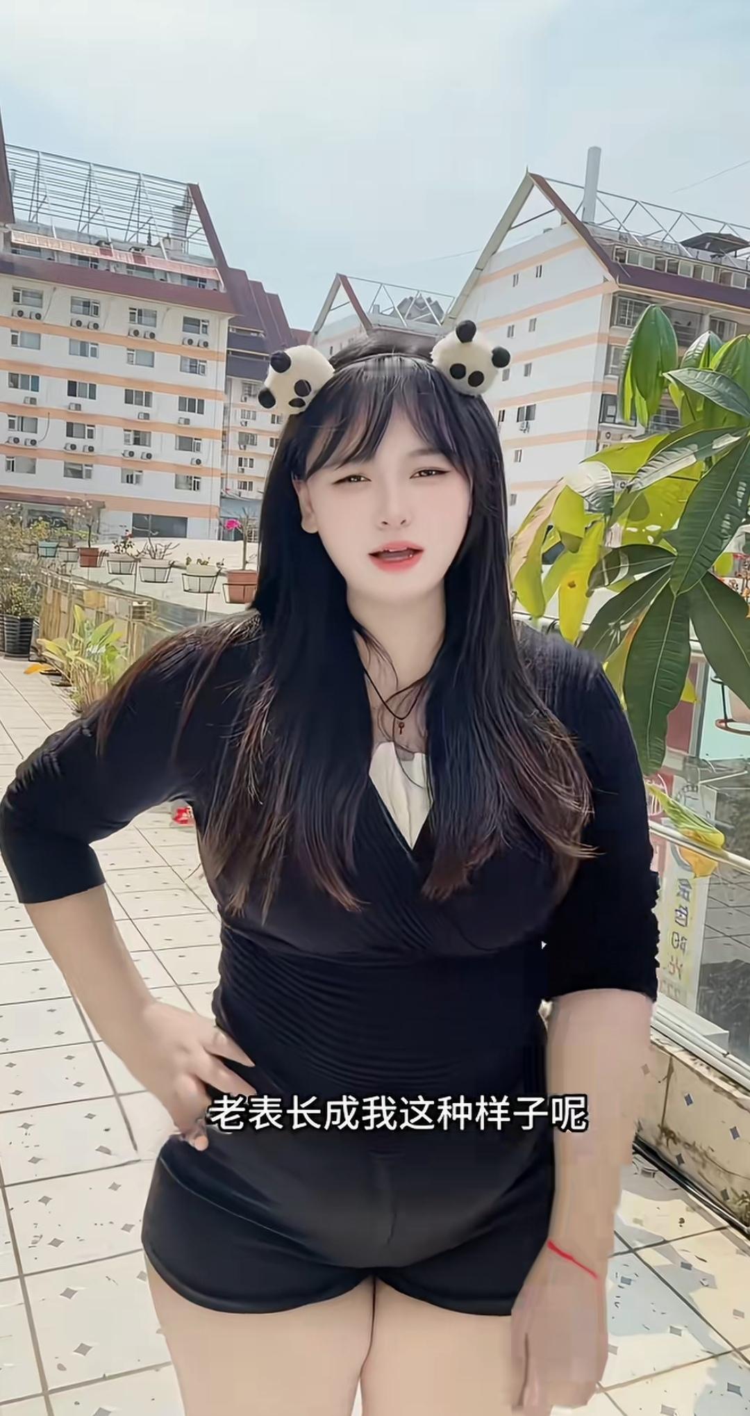 穿黑色衣服，戴熊猫头饰的女孩。