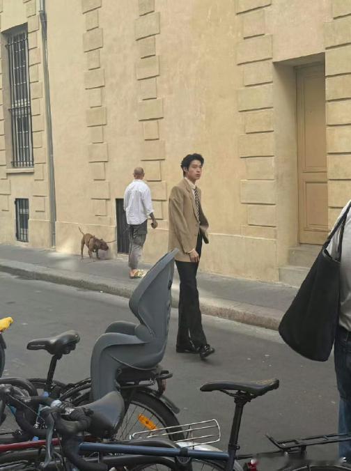 魏大勋现身巴黎街头参与拍摄，网友偶遇的照片中他正在认真配合摄影师的要求，工作态度