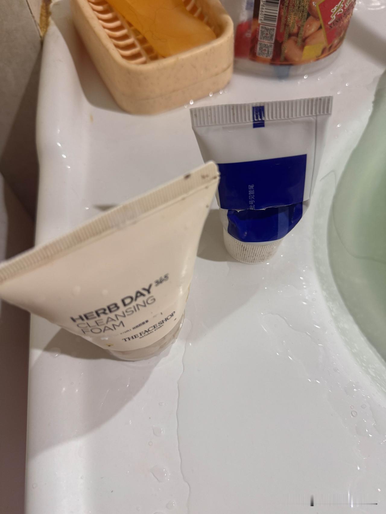 台面上，一个剪开的洗面奶，一个是剪开的牙膏。

在我家，洗面奶和牙膏没有一个能完
