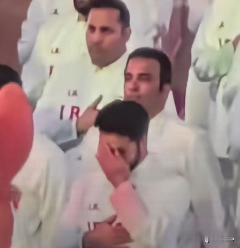 太感人！伊朗代表团亮相入场，全员将右手放在胸前表情严肃，有代表在入场时偷偷抹眼泪