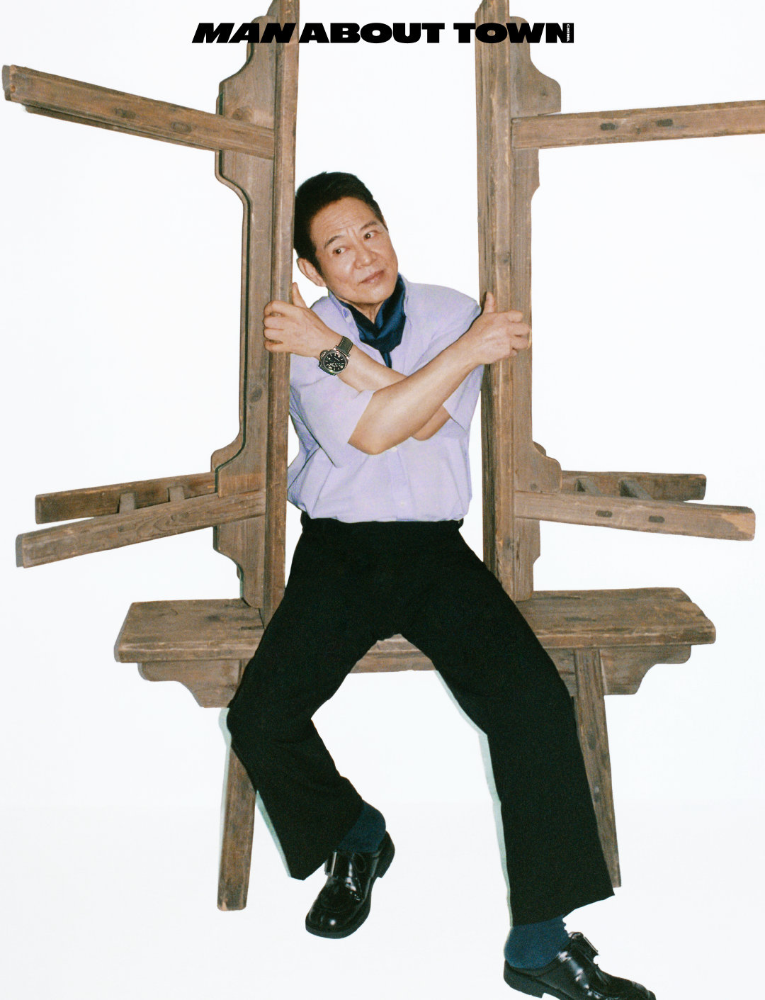 李连杰身着速写黑支线系列浅蓝色衬衫搭配藏青领巾，沉稳身姿尽显宗师姿态，于旧木结构